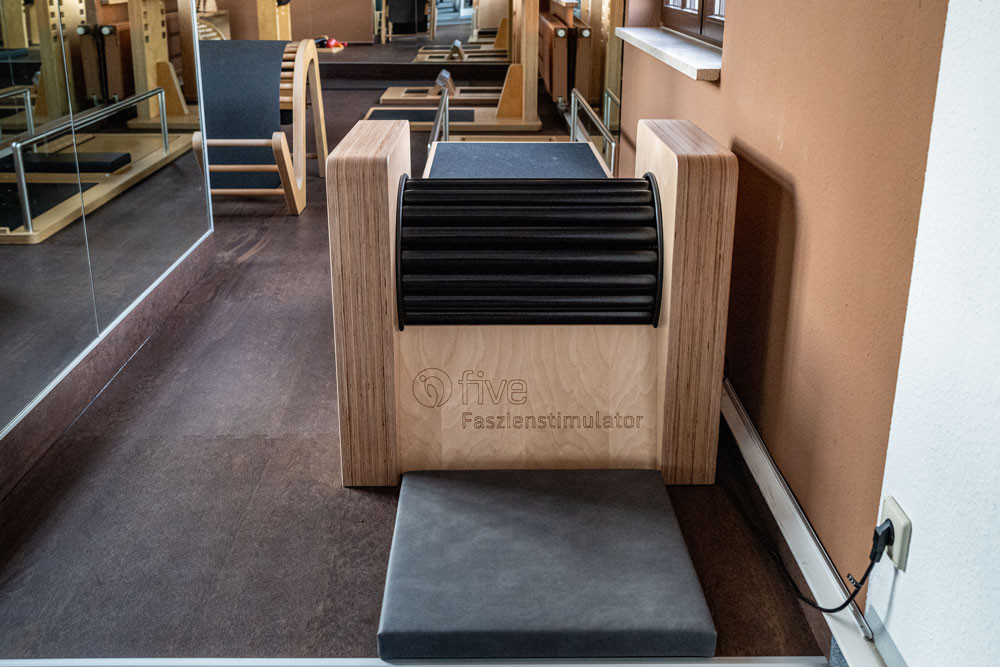 In einem Raum mit verspiegelter Wand  stehen Geräte aus Holz und Metall.
